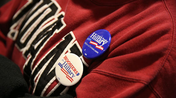 A supporter of Democratic presidential candidate Hillary Clinton wears campaign buttons as she listens to former President Bill Clinton at an event in Indiana.