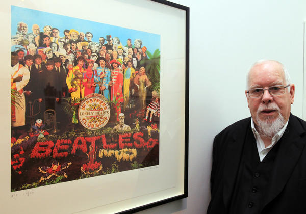 Pop artist Peter Blake poses beside a copy of the <em>Sgt. Pepper's Lonely Hearts Club Band </em>album cover, which he co-designed in 1967.