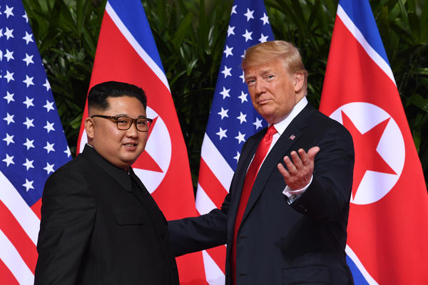 President Trump gestures to reporters as he meets with North Korea's leader Kim Jong Un at the start of the U.S.-North Korea summit in Singapore on Tuesday.