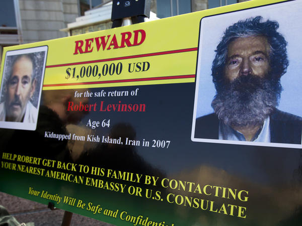 An FBI poster from 2012 shows a composite image (right) of former FBI agent Robert Levinson depicting how he would look after five years in captivity. The poster includes another image taken from a video released by his kidnappers.