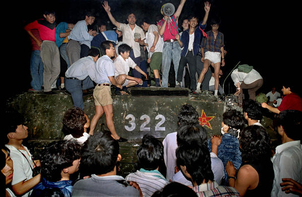 Civilians hold rocks as they stand on a government armored vehicle near Chang'an Boulevard in Beijing, early June 4, 1989, before the army began a crackdown on pro-democracy protesters in and around Tiananmen Square.