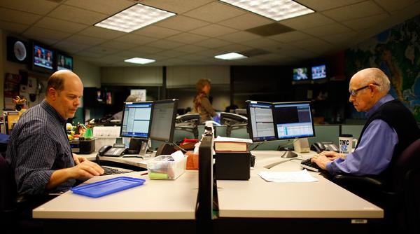 Jim Howard (left) edits the newscast, while Kasell works on his scripts in preparation for going on the air, on Dec. 29.