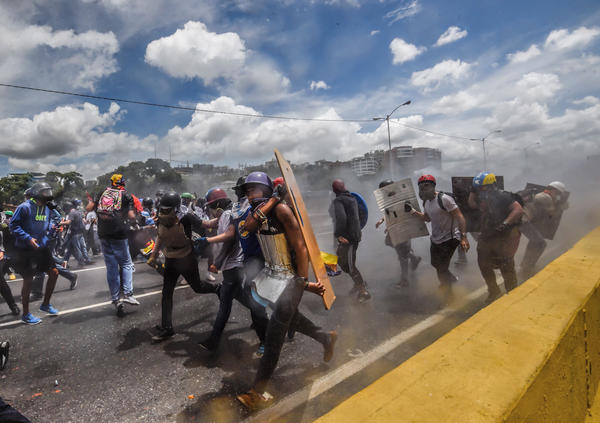 Opposition activists clash with riot police during a demonstration against the government of President Nicolas Maduro along the Francisco Fajardo Highway in Caracas on June 19.