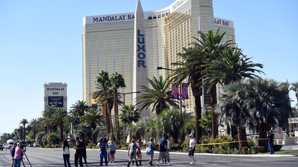 People cross the Las Vegas Strip where a lone gunman opened fire on the audience at the Route 91 Harvest country music festival Sunday night. The gunman, identified as Stephen Paddock, 64, of Mesquite, Nev., fired from a room on the 32nd floor of the Mandalay Bay Resort and Casino.