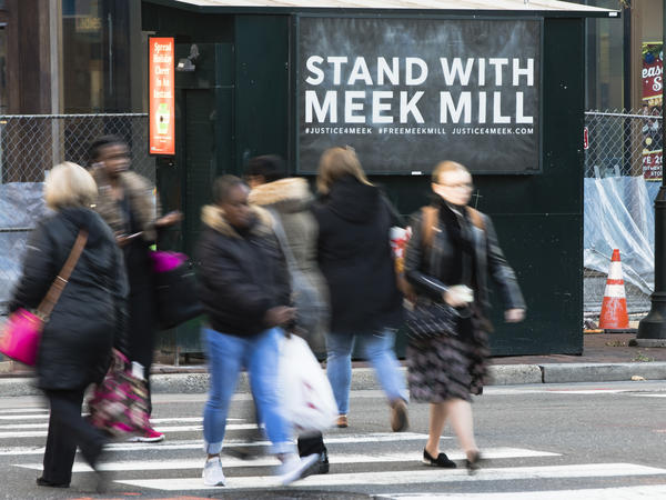 People in Philadelphia walk past a placard posted on a newsstand with a message of support for imprisoned rapper Meek Mill. Mill's imprisonment on a probation violation set off a flurry of legal appeals, criticism of the criminal justice system and rallies in the city last fall.