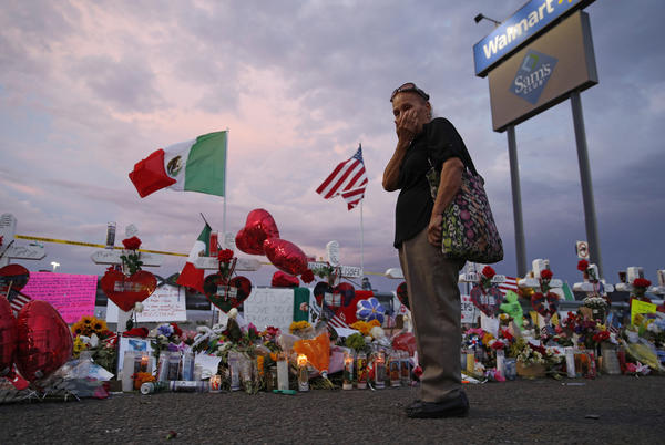 Catalina Saenz wipes tears from her face as she visits a makeshift memorial near the scene of a mass shooting at a shopping complex in El Paso, Texas. A list of the people who died in the weekend shooting rampage at the Walmart, shows that most of the victims had Latino surnames and included one German national.