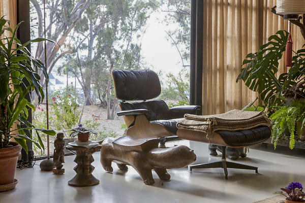 An Eames lounge chair and ottoman sit in the living room.
