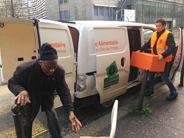 Ahmed "Doudou" Djerbrani, in the orange vest, delivers the food French supermarkets must donate to food banks by law.