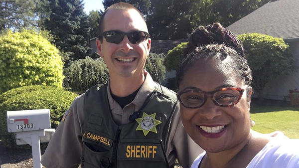 Oregon state Rep. Janelle Bynum poses with the Clackamas County sheriff's deputy who responded to a call from someone who said Bynum was casing the neighborhood. The legislator said she was going door to door talking to constituents.