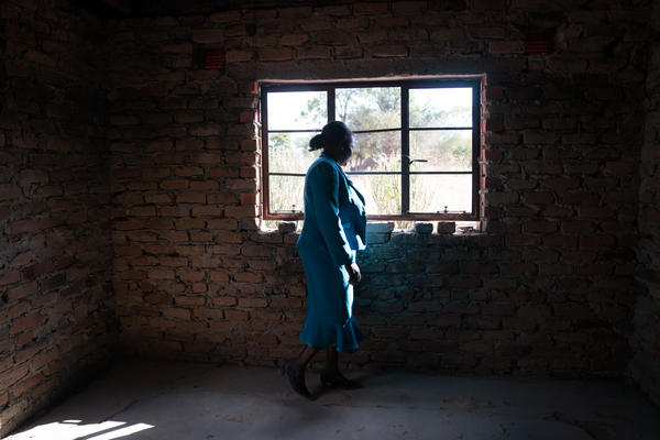 Florence Machinga, a candidate for the opposition MDC party, looks out the window of her house, which was burned down 10  years ago by an angry mob. The incident was one in a wave of violence carried out against MDC supporters in 2008. Machinga is still slowly rebuilding the home.
