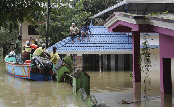 Volunteers in a boat help to rescue stranded people from a flooded area in Chengannur in the southern state of Kerala, India, on Sunday.