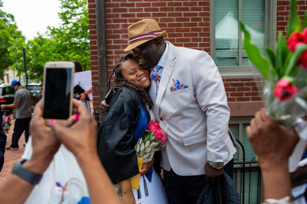 Rashema Melson gets a hug and has her photo taken with her cousin Anthony Young after the 2019 Georgetown University graduation ceremony.