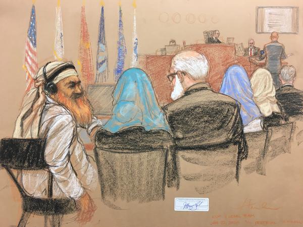 Alleged Sept. 11 mastermind Khalid Sheikh Mohammed (far left) consults with his defense attorneys in the U.S. military courtroom in Guantánamo Bay, Cuba, as a man who waterboarded him, retired Air Force psychologist James Mitchell, takes the stand.