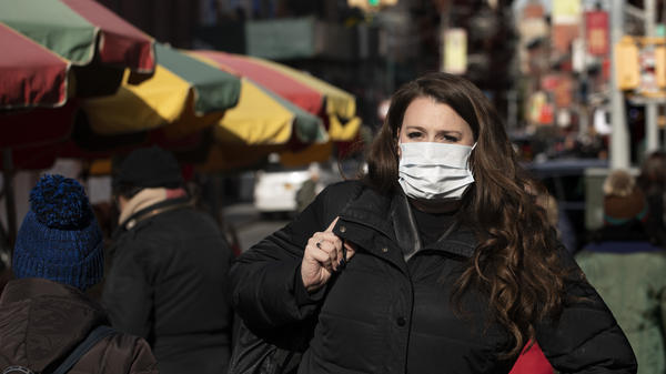 A woman wears a mask in New York out of concern for the newly emerged coronavirus. However, experts say that the commonly worn surgical masks aren't very effective protection.