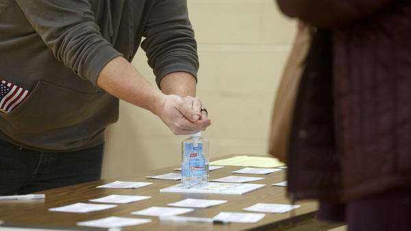 A Michigan voter uses hand sanitizer that the polling place provided after casting his ballot at Warren Woods Baptist Church in Warren, Mich., last week.