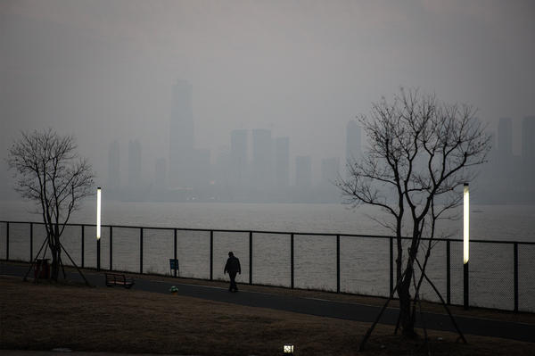 A man walks along the Yangtze River in Wuhan, the city in China where the novel coronavirus was first identified.