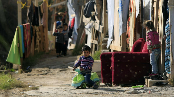 A Syrian refugee boy plays outside his family's tent in a Syrian refugee camp in the town of Zahrani, Lebanon, in December. Some 1 million Syrians live in Lebanon as refugees, according to the U.N.
