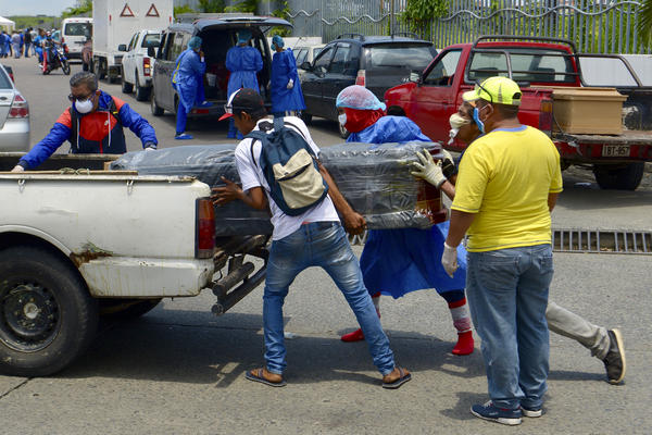 Men load a coffin onto a pickup truck in front of General del Guasmo Sur Hospital in Guayaquil, Ecuador. The port city is the most affected by COVID-19 in the country. Corpses lie in apartments for days and morgues are overcrowded. The city administration requested four refrigerated containers in which the corpses can be temporarily stored.