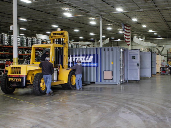 Workers inside a warehouse in Columbus, Ohio, prepare Battelle's decontamination units for deployment.