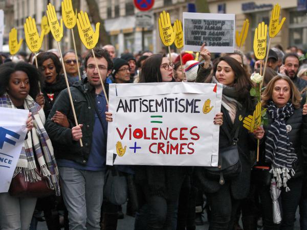 Demonstrators hold signs against anti-Semitism during a silent march in Paris on March 28 in memory of Mireille Knoll, an 85-year-old Jewish woman murdered in her home in what police believe was an anti-Semitic attack. Knoll escaped the mass deportation of Jews from Paris during World War II.