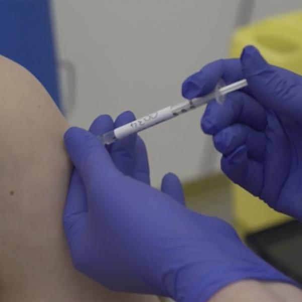Footage issued by Britain's Oxford University shows a person injected as part of human trials in the U.K. to test a potential coronavirus vaccine last month. Pfizer on Monday began U.S. trials of another vaccine candidate.