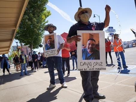 Farmworkers in Yakima, Washington's fruit packing industry walked off production lines in May and went on strike, demanding more protections against the coronavirus pandemic. Above, Emmanuel Anguiano-Mendoza (left) and Agustin López hold posters featuring David Cruz, a worker who died on May 30.