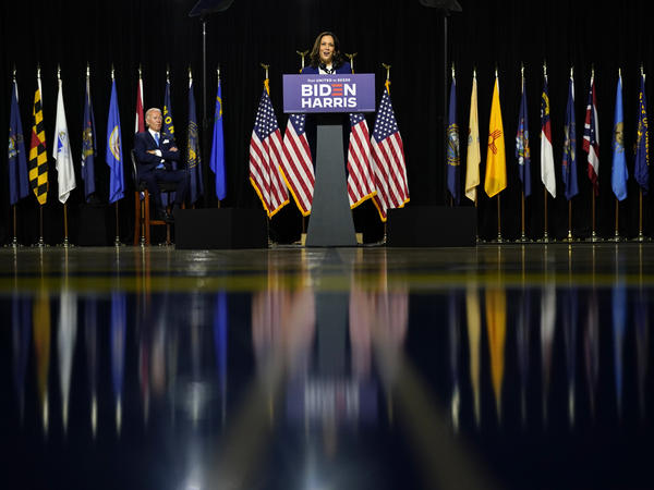 Presumptive Democratic presidential nominee and former Vice President Joe Biden listens as his running mate Sen. Kamala Harris, D-Calif., speaks during a campaign event at Alexis Dupont High School in Wilmington, Del.