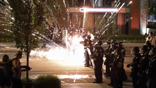 A firework explodes by a police line as demonstrators gather to protest the death of George Floyd on Saturday near the White House in Washington.