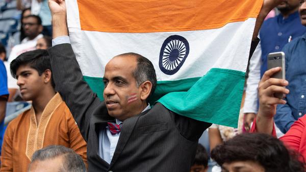 A man holds up an Indian flag during a rally with President Trump and Prime Minister Modi in Houston in September 2019. Trump and Modi have spoken of their friendship, but most Indian Americans say U.S.-India ties are low on their political priorities.