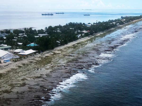 The ocean (right) and the lagoon (left) are separated by a thin strip of land in Funafuti, Tuvalu. The small South Pacific island nation is striving to mitigate the effects of climate change. Tuvalu's 11,000 inhabitants see effects such as rising sea levels in their daily life.