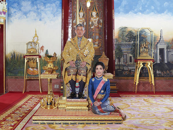 In this undated photo posted Aug. 26, 2019, on the Thailand Royal Office website, Thailand's King Maha Vajiralongkorn sits on the throne with his official consort Sineenatra Wongvajirabhakdi at the royal palace.