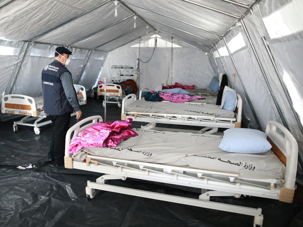 The World Health Organization is is "absolutely critical to the world's efforts to win the war against COVID-19," U.N. Secretary-General António Guterres said, after President Trump said he will halt funding to the agency. Here, a WHO staff member inspects a coronaviruus quarantine facility at the Rafah border crossing in the southern Gaza Strip in March.