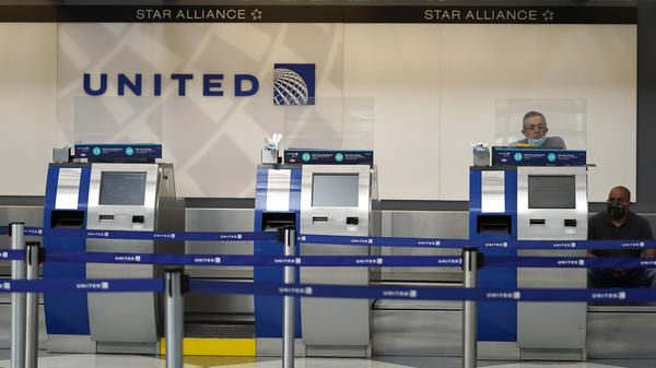 United Airlines employees work at ticket counters at Chicago's O'Hare International Airport on Oct. 14. United and other airline stocks have been hard-hit by the pandemic economic slowdown.