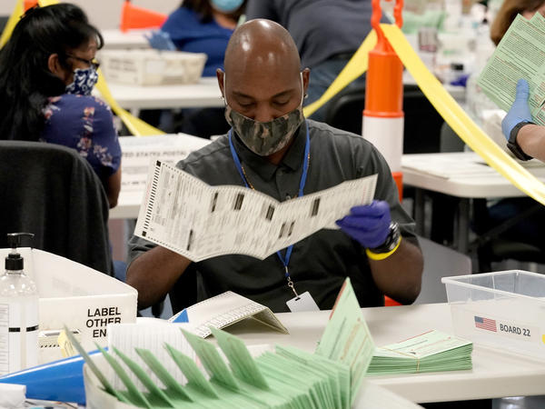 Election workers sort ballots at the Maricopa County Recorder's Office in Phoenix. Mail-in ballots in Arizona are already being counted.
