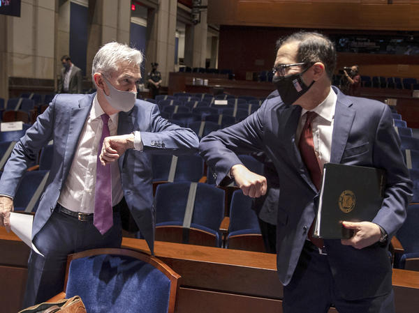 Federal Reserve Chairman Jerome Powell, left, and Treasury Secretary Steven Mnuchin bump elbows after concluding their testimony before Congress on June 30. The Fed and Treasury engaged in a rare clash over the fate of key pandemic lending programs.