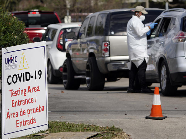 A healthcare worker processes people in line at a United Memorial Medical Center COVID-19 testing site on Nov. 19, in Houston. Texas is rushing thousands of additional medical staff to overworked hospitals as the number of hospitalized COVID-19 patients increases.