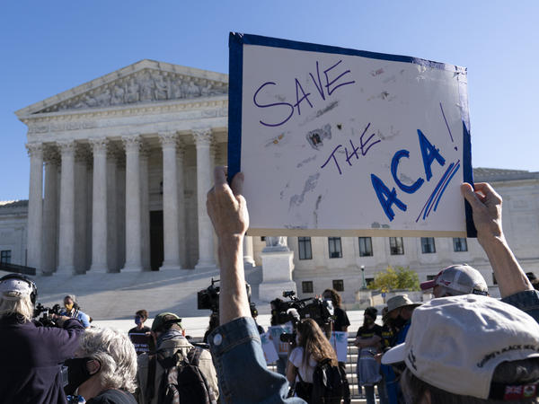 A demonstrator holds a sign in front of the U.S. Supreme Court, which heard arguments Tuesday on the future of the Affordable Care Act.