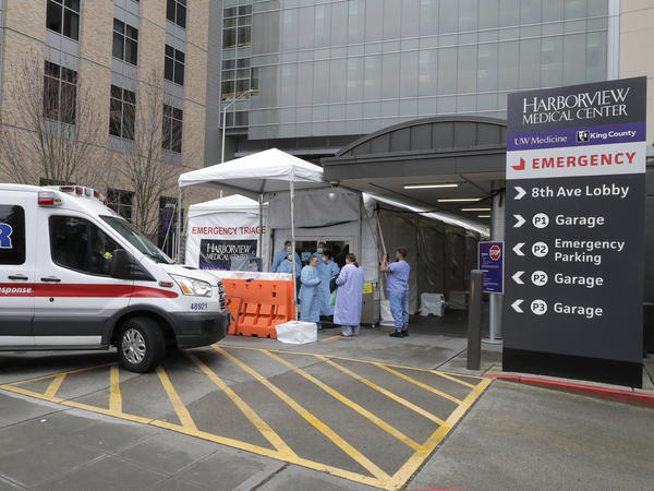 An ambulance pulls up as nurses outside a triage tent for the Emergency Department at the Harborview Medical Center in Seattle put on gowns and other protective gear at the start of their shift, on April 2, 2020. A resurgence of the coronavirus has health care workers and government leaders worried about dwindling resources and an exhausted workforce.