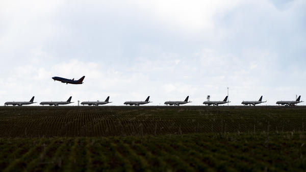 A Southwest Airlines flight takes off as United Airlines planes sit parked on a runway at Denver International Airport in April.