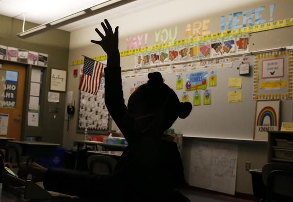 A first-grader raises her hand at Mary L. Fonseca Elementary School in Fall River, Mass., in November.