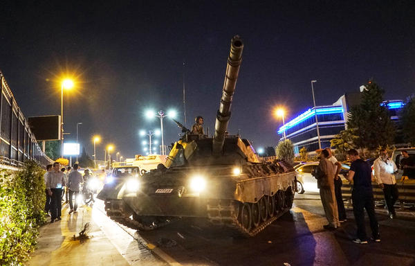 People gather near a Turkish army tank in Istanbul on July 16, after a group within Turkey's military attempted a coup. Since then, more than 100,000 people been detained, fired or suspended from their jobs on suspicion of sympathizing with or aiding the coup attempt.