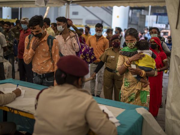 Passengers register at a counter before being tested for COVID-19 at a bus terminal on Wednesday in New Delhi.