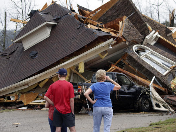 Residents survey damage to homes after a tornado touched down south of Birmingham, Ala., in the Eagle Point community damaging multiple homes on Thursday.