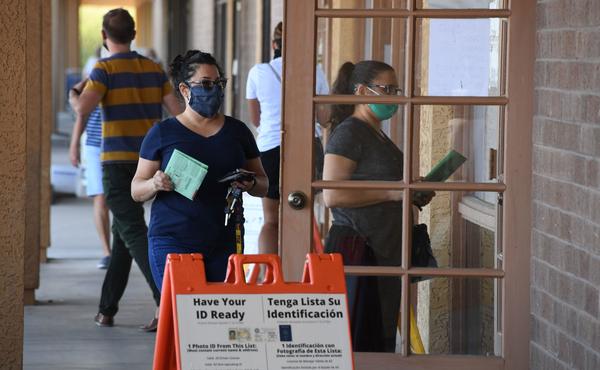 People arrive to drop off mail-in ballots or vote in person at an early voting location in Phoenix on Oct. 16, 2020. Republicans in Arizona are weighing measures to make the state's voting rules more restrictive.