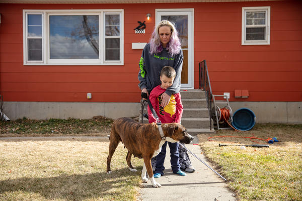 Barbara Gaught stands outside the home she's now renting in Billings, Mont., with her 5-year-old son, Blazen, and their dog, Arie. Gaught and her family were evicted from the mobile home they had owned outright and lived in for 16 years because they fell behind on 'lot rent' for the little plot of land under the mobile home.