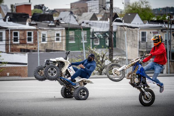 Instructor Harold Toms (left) and participant Tathaiso Martin, 18, ride wheelies in a Baltimore parking lot. B-360, run by founder Brittany Young, is a program that seeks to offer alternatives to recklessly riding dirt bikes and ATVs on city streets.