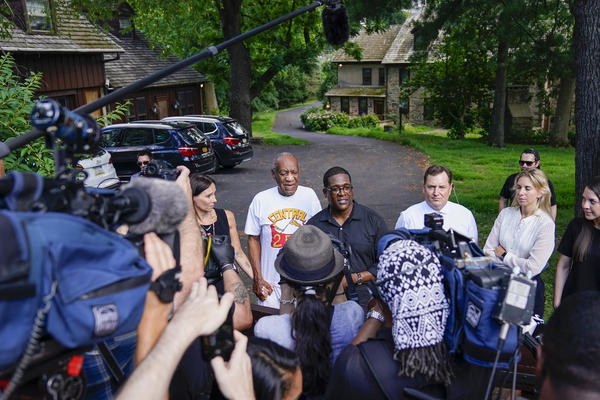 Bill Cosby (center left) and spokesperson Andrew Wyatt (center right) approach members of the media gathered outside Cosby's home in Elkins Park, Pa., on Wednesday after the comedian was released from prison.