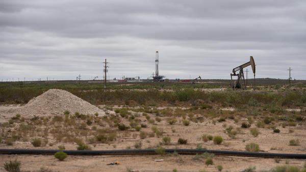 A horizontal drilling rig and a pump jack sit on federal land in Lea County, N.M., in September. The state stands to lose royalties and revenue from a Biden administration pause on new oil and gas leases.