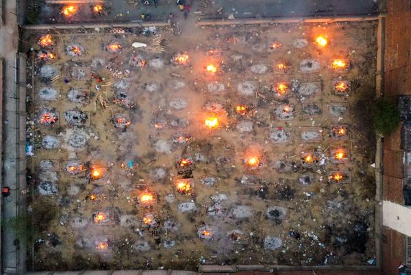 Victims of COVID-19 are cremated in funeral pyres this week in New Delhi. Scientists says the real death toll and number of infections are likely much higher than what the Indian government is reporting.