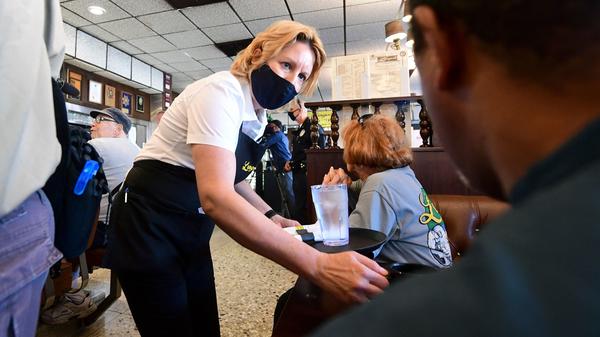 A waitress wears a face mask while serving at Langer's Delicatessen-Restaurant in Los Angeles on June 15.